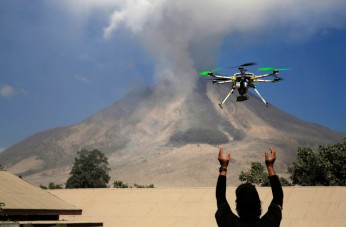 An official of the Center for Research and Technology Volcanoes Development (BPPTK) releases a drone quadcopter to monitor activity from the Mount Sinabung volcano at Sibintun village in Karo district